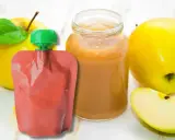 Jabłkowe puree w słoiczku i saszetce, idealne jako soki dla niemowląt od 3 miesiąca. Obok świeże jabłka.