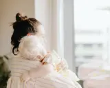 Madre abraza a su hijo de 2 años que no quiere dormir, con la cabeza apoyada en su hombro.