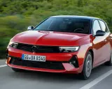El nuevo Opel Astra rojo, con techo negro, circula por una carretera sinuosa rodeada de vegetación.