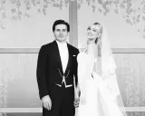 Novios sonrientes en la boda Brooklyn Beckham. Él con esmoquin, ella con velo y vestido blanco.