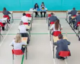 Uczniowie piszą egzamin, prawdopodobnie matura rozszerzona angielski jaki poziom. Nauczyciele nadzorują.