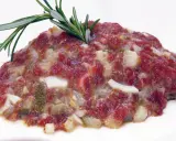 Delicioso steak tartar de los Hermanos Torres, con carne picada, cebolla, pepinillos y un toque de romero.