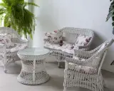 Conjunto de muebles de mimbre blanco con cojines florales, ideal para restaurar muebles de mimbre y darles un toque fresco.