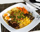 Apetyczny tantanmen z jajkiem na pół, kukurydzą, marchewką i grzybami.