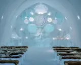 Vacker iskyrka i ett igloo hotell Sverige. Bänkar av is med renskinn, isrosor och levande ljus skapar en magisk atmosfär.