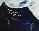 Okładka książki "Mleko i miód" Rupi Kaur z motywem pszczoły na granatowym tle w gwiazdy.