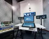 Profesjonalny komputer do muzyki w studiu nagraniowym, z monitorami studyjnymi i rackiem sprzętu audio.