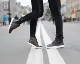 Para, gdy buty farbują od środka, co zrobić? Stylowe brązowe trampki na ulicy.