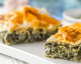Chrupiąca spanakopita z warstwami ciasta filo i zielonym nadzieniem ze szpinaku i sera.
