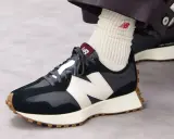 Jak wiązać sznurówki w sneakersach New Balance? Zobacz, jak elegancko prezentują się te ciemne buty z białym logo.