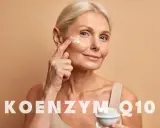 Kobieta aplikuje krem z koenzymem Q10 na skórę wokół oczu. Koenzym Q10 na co? Na odmłodzenie i regenerację.