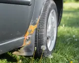Widoczna rdza na drzwiach samochodu, która postępuje od progu.