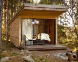 Mysig koja i skogen, perfekt för att bo i som ett skogshotell. Två fårskinnsbeklädda stolar på altanen inbjuder till avkoppling.
