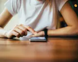 Dłoń dotyka ekranu telefonu, być może wykonując twardy reset Xiaomi.