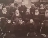 Grupa zakonników w habitach. W środku, w pierwszym rzędzie, siedzi młody mężczyzna, być może to **Honorat Koźmiński** w otoczeniu braci.