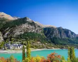 Pueblo de Lanuza, Huesca, con su embalse de aguas turquesas y montañas verdes.
