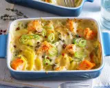 Herzhaftes Fischgericht mit Kartoffeln, überbacken mit Käse und garniert mit Frühlingszwiebeln und rosa Pfeffer.
