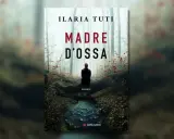 Copertina del romanzo "Madre d'ossa" di Ilaria Tuti. Una figura solitaria siede in un bosco nebbioso, vicino a un ruscello.