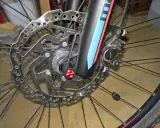 Hamulec tarczowy roweru z mocowaniem **center lock**. Widoczna tarcza hamulcowa Shimano, zacisk i szybkozamykacz DT Swiss.