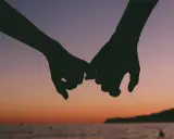Siluetas de dos manos entrelazadas al atardecer, un gesto de apoyo mutuo, un rol de salvadora que se siente en la unión.