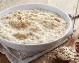 Schüssel mit Haferbrei, daneben Haferflocken und Buchweizen. Gute Haferkur Erfahrungen beginnen mit einem gesunden Frühstück.