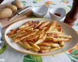 Patatas fritas doradas y crujientes, recién salidas de la freidora de aire. Perfectas para acompañar cualquier comida.
