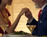 Romantyczna kolacja, gdzie różnica wieku nie stanowi przeszkody. Mężczyzna całuje dłoń młodej kobiety.