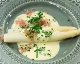 Vit sparris i en krämig sås till sparris, toppad med örter och rosa rom. En delikat rätt.
