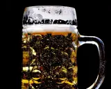 Złocisty lager w szklanej, tłoczonej kuflu, z obfitą pianką. Idealny rodzaj piwa na gorący dzień.