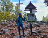 Kobieta na szczycie Łysicy, 614 m n.p.m., przy drogowskazie szlak łysica - kakonin. Jesień w pełni, liście na ziemi.