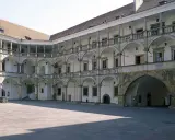 Dziedziniec zamku na brzeg opolski. Arkadowe krużganki otaczają plac, tworząc malowniczą przestrzeń.
