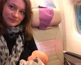 Kobieta karmi niemowlaka podczas lotu samolotem.