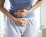 Kobieta trzyma się za brzuch, cierpiąc z powodu bólu menstruacyjnego nie do zniesienia.