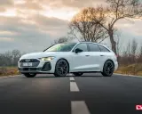 Białe Audi A5 Avant 2025 na drodze, z drzewami w tle.