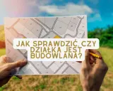 Ręce trzymają mapę z podziałem działek, z tekstem "Jak sprawdzić, czy działka jest budowlana?".