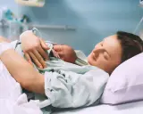 Szczęśliwa mama tuli noworodka po porodzie, czując ulgę po znieczuleniu.