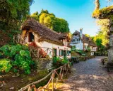 Casitas de cuento con tejados de paja, perfectas para crear viajes inolvidables para adolescentes. Un camino empedrado y vegetación exuberante.
