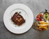 En saftig biff med vitlök, pommes frites, tomatsallad och bearnaisesås. En måltid som får en att vilja skriva restaurang Prinsens recensioner.