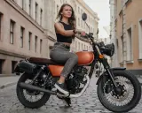 Kobieta na motocyklu 125, gotowa na jazdę po mieście. Jej prawo jazdy czeka na przygodę.