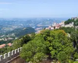 Panoramica mozzafiato di San Marino, con le sue torri medievali che dominano il paesaggio collinare, un luogo da sogno vicino a Rimini.