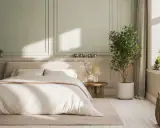 Chambre paisible avec lit douillet, murs aux moulures élégantes et une plante verte. Idée de deco peinture chambre pour une ambiance sereine.
