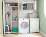Lavadora, secadora y armario con aspiradora, plancha y productos de limpieza. Ideas para un lavadero funcional y ordenado.