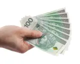 Dłoń trzyma kilka banknotów 100 zł. Może to symbolizować pieniądze potrzebne na zachowek od darowizny.