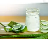 Tranches d'aloe vera et un verre rempli de sa pulpe translucide, évoquant les nombreux aloe vera bienfaits pour la santé et la peau.