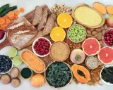 Vielfalt an ballaststoffe produkten: Vollkornbrot, Linsen, Beeren, Nüsse, Obst und Gemüse für eine gesunde Ernährung.