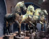 Les célèbres chevaux de Saint-Marc, statues de bronze patiné, se dressent fièrement dans un musée, leurs corps musclés capturant l'essence de la puissance antique.