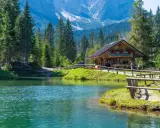 Rifugio alpino in Italia, con lago cristallino e montagne sullo sfondo. Perfetto per una vacanza in montagna Italia.