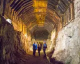 Trzech turystów w kaskach oświetla latarkami drewniany tunel. Czy to osówka czy włodarz?
