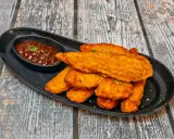 Chrupiące kawałki kotleta drobiowego w panierce, podane z sosem BBQ. Idealne na przekąskę lub danie główne.