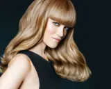 Frau mit glänzendem, kupferblondem Haar und einem eleganten Schnitt.